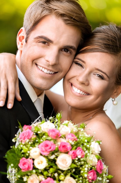 Feliz pareja joven recién casada con flores