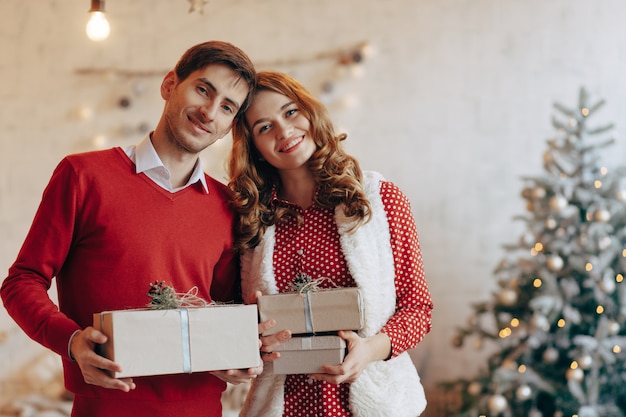 Feliz pareja joven con regalos de Navidad