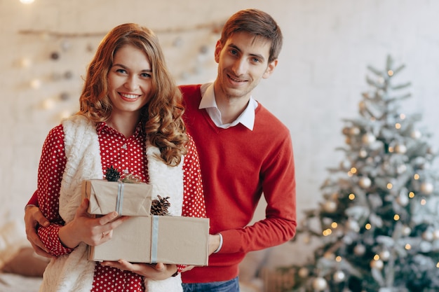 Feliz pareja joven con regalos de Navidad