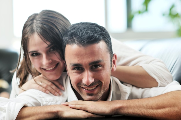 feliz pareja joven relajarse en casa moderna salón interior