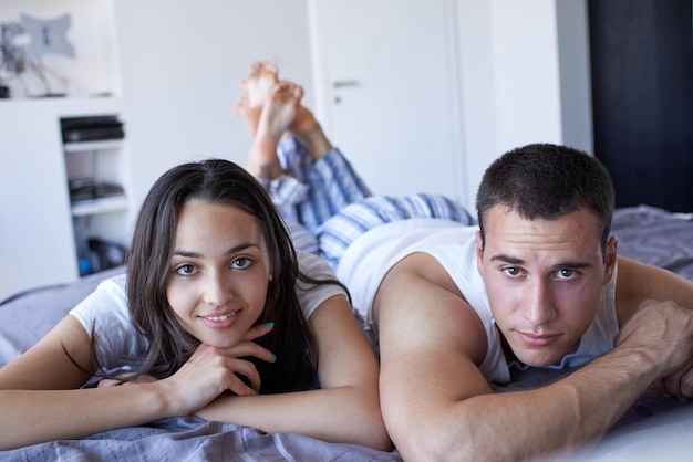 feliz pareja joven relajarse y divertirse en la cama