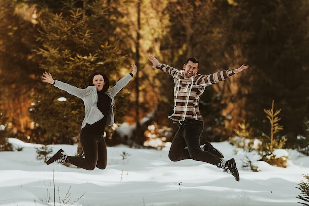 Feliz pareja joven saltando y jugando al aire libre Temporada de invierno Enfoque selectivo