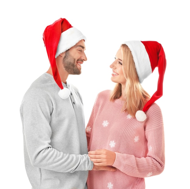 Feliz pareja joven con sombreros de Santa aislado. Concepto de navidad