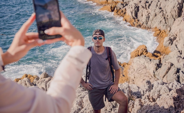 Una feliz pareja joven sube a la cima de las montañas cerca del océano