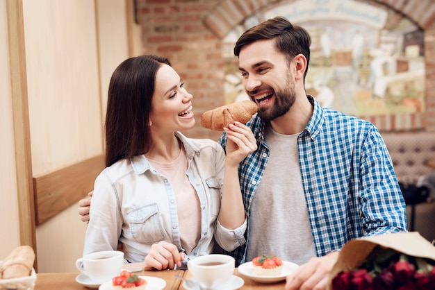 Feliz pareja joven tiene cita en la cafetería moderna.