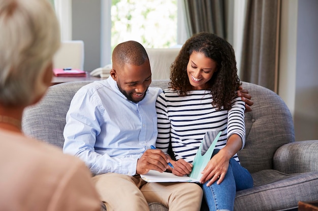 Feliz pareja joven tomando consejos financieros en casa