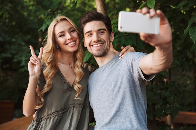 Foto feliz pareja joven tomando un selfie juntos