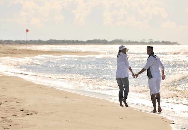 feliz pareja joven vestida de blanco tiene recreación romántica y diversión en la hermosa playa de vacaciones