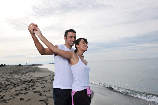 feliz pareja joven vestida de blanco tiene recreación romántica y diversión en la hermosa playa de vacaciones