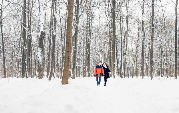 Feliz pareja joven en Winter Park divirtiéndose. Familia al aire libre.