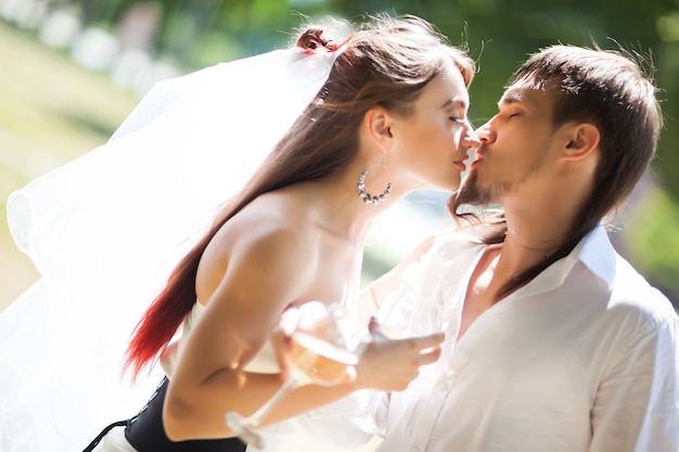 Foto feliz pareja de jóvenes besándose al aire libre.