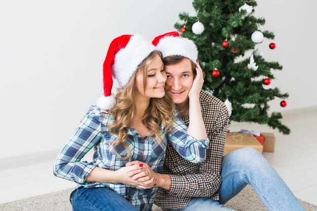 Feliz pareja de jóvenes celebrando la Navidad en casa.