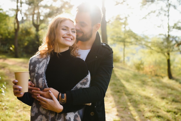 Feliz pareja de jóvenes enamorados al aire libre en otoño