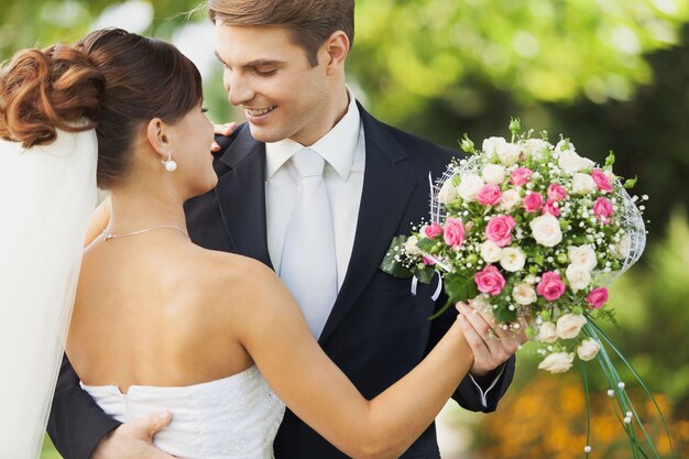 Feliz pareja de jóvenes recién casados con flores