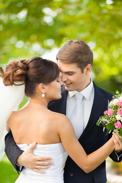 Feliz pareja de jóvenes recién casados con flores