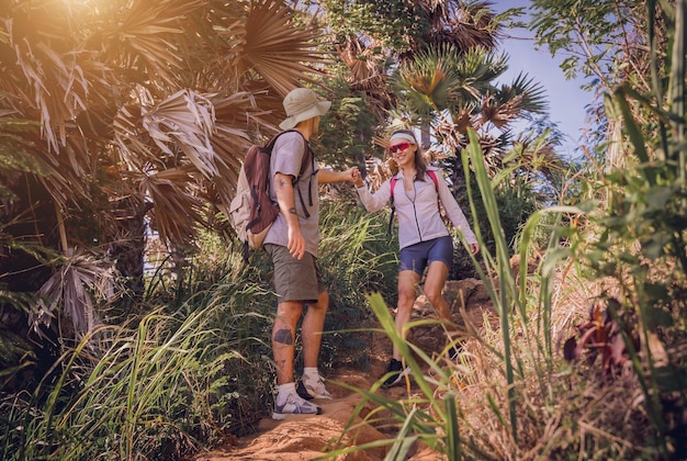 Foto una feliz pareja de jóvenes viajando en la selva cerca del océano.