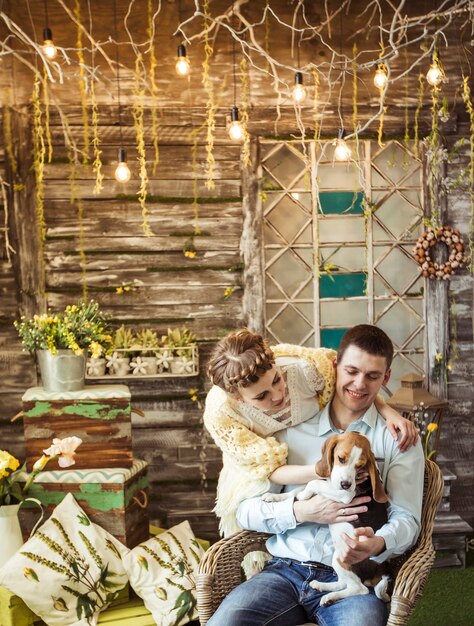 Feliz pareja jugando con su amado perro en la sala de estar