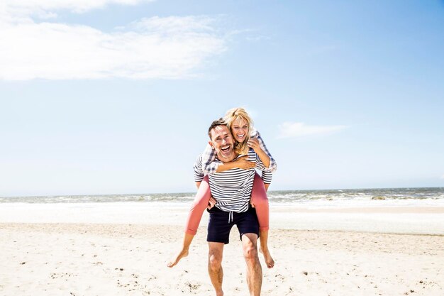 Feliz pareja juguetona en la playa