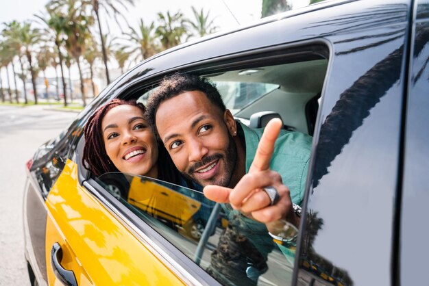 Feliz pareja latina hispana tomando un taxi