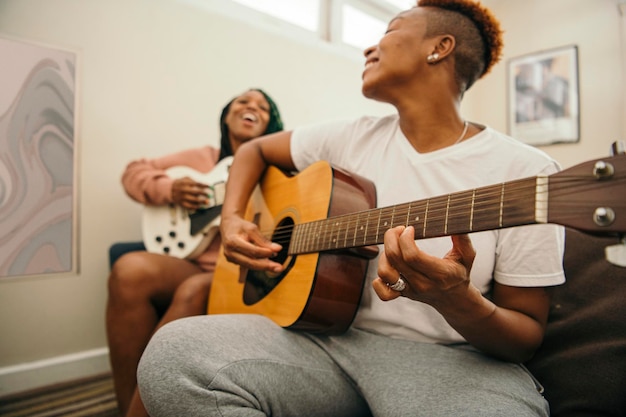 Feliz pareja de lesbianas disfrutando tocando música juntos