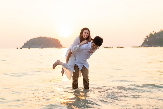 Feliz pareja va de luna de miel a viajar en la playa de arena tropical en verano