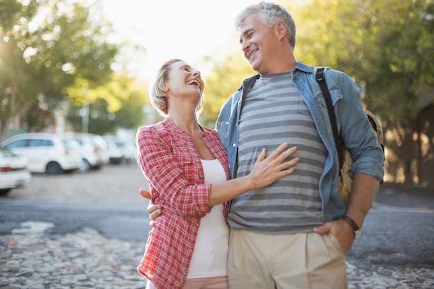 Feliz pareja madura abrazando en la ciudad