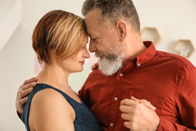 Feliz pareja madura bailando en casa