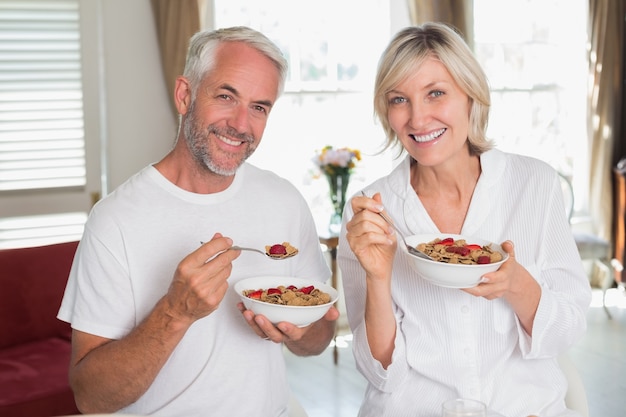 Feliz pareja madura desayunando en casa