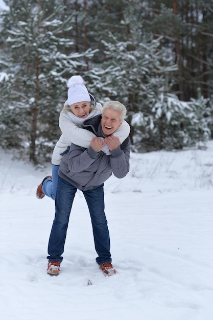 Feliz pareja madura divertirse al aire libre en invierno