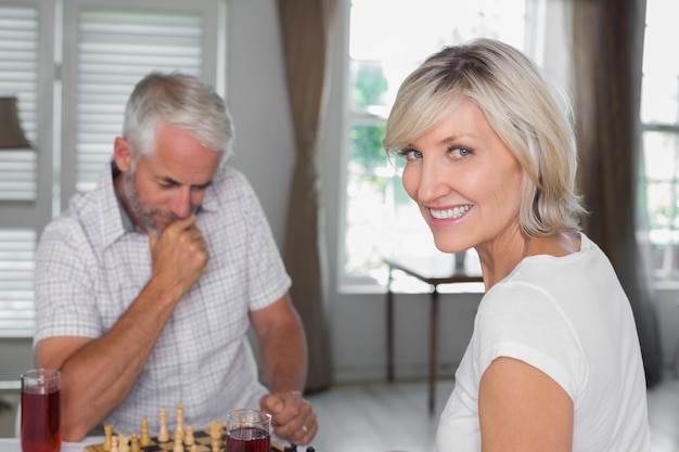 Feliz pareja madura jugando al ajedrez en casa