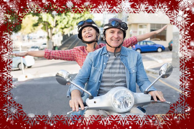 Foto feliz pareja madura montando una moto en la ciudad contra la nieve