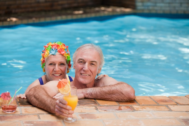 Feliz pareja madura en la piscina