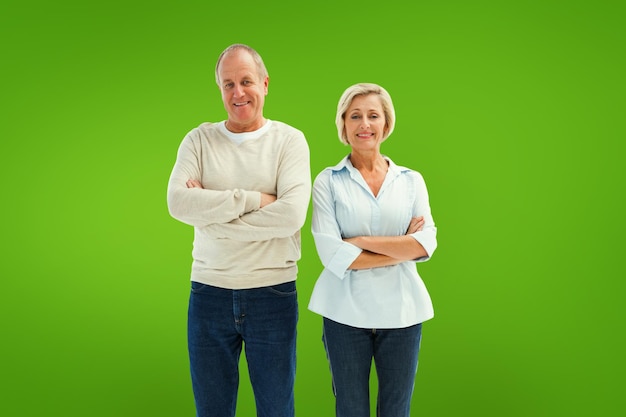 Feliz pareja madura sonriendo a la cámara contra la viñeta verde