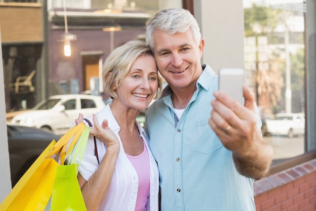 Feliz pareja madura tomando un selfie juntos en la ciudad