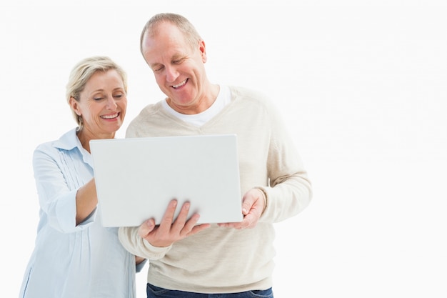 Feliz pareja madura usando laptop