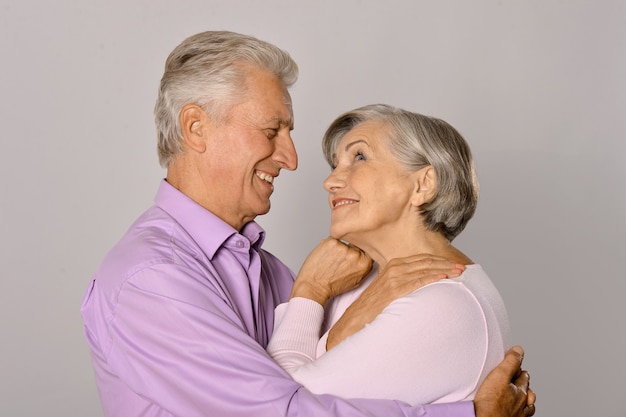 Feliz pareja mayor sobre un fondo gris