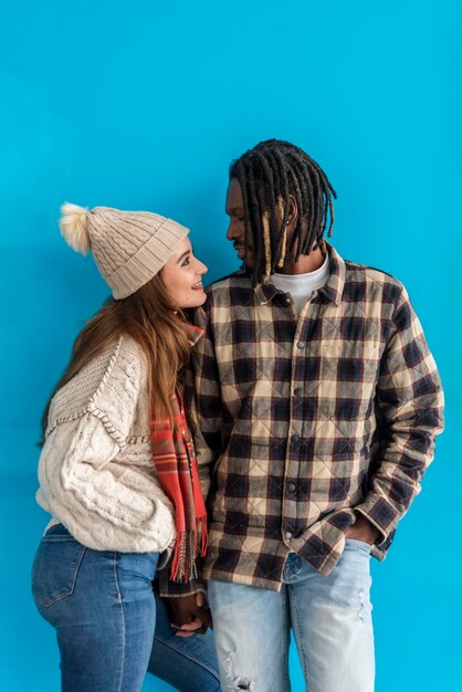 Una feliz pareja multirracial mirándose en un fondo azul