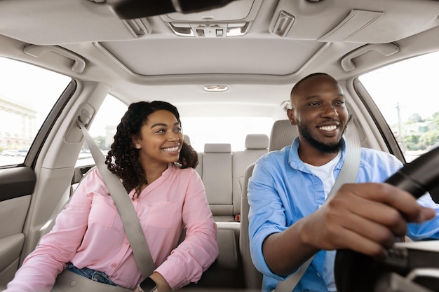 Feliz pareja negra disfrutando de un largo viaje en auto