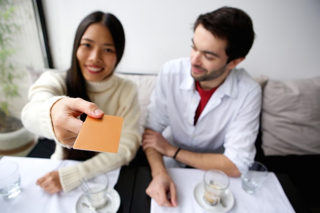 Feliz pareja pagando comida con tarjeta en el restaurante