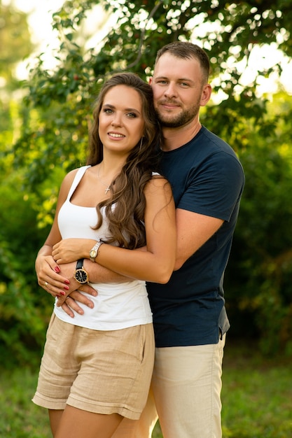 Foto feliz pareja en un picnic sonriendo el uno al otro en un día soleado.la gente, el amor, la felicidad y el concepto de naturaleza