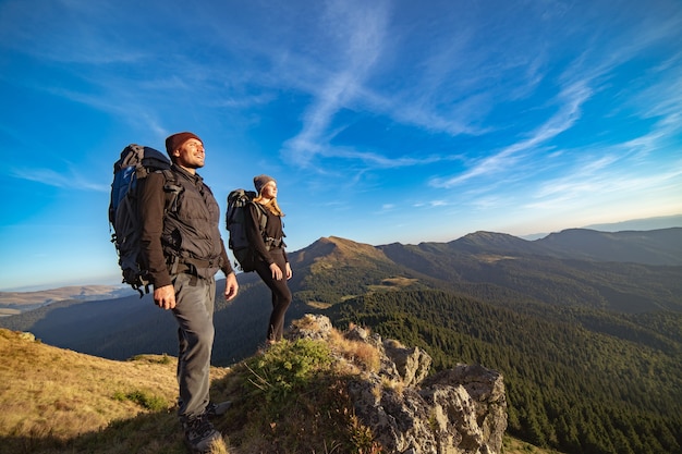 Foto la feliz pareja de pie en la montaña soleada