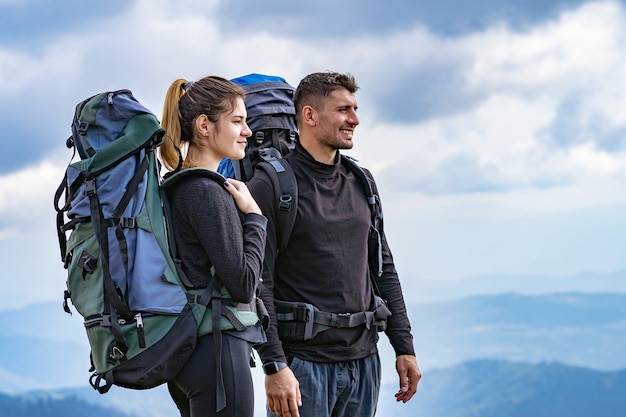 La feliz pareja de pie en la montaña