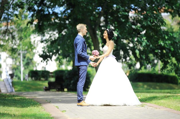 Feliz pareja de pie en el parque el día de la boda