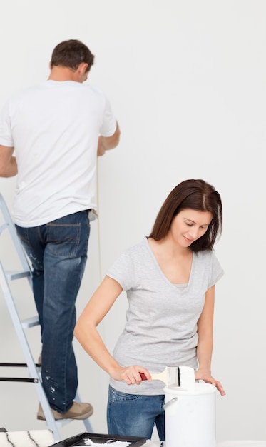 Feliz pareja pintando juntos una habitación