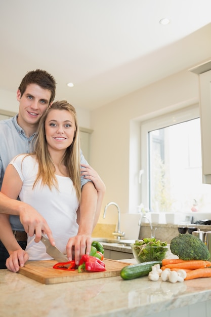 Feliz pareja preparando verduras