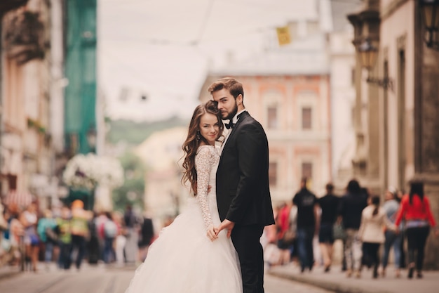 Feliz pareja de recién casados abrazando en la calle