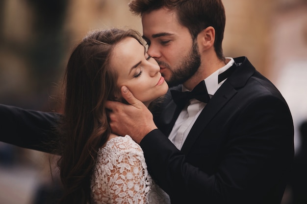 Feliz pareja de recién casados abrazándose y besándose
