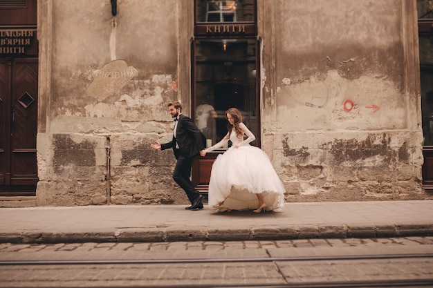 Feliz pareja de recién casados caminando por la calle