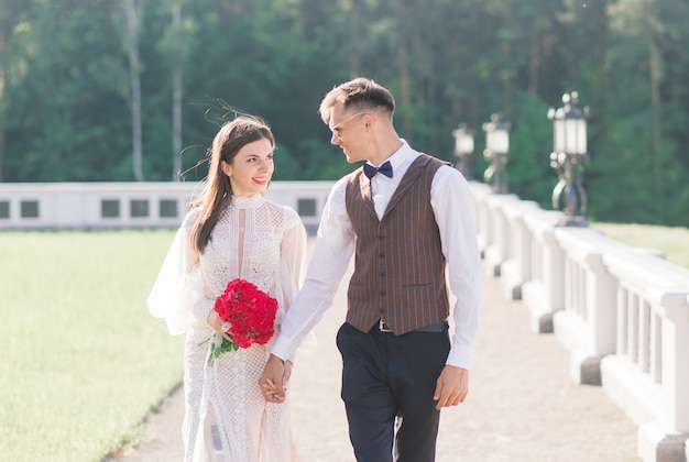 Feliz pareja de recién casados celebrando y diviértete al aire libre