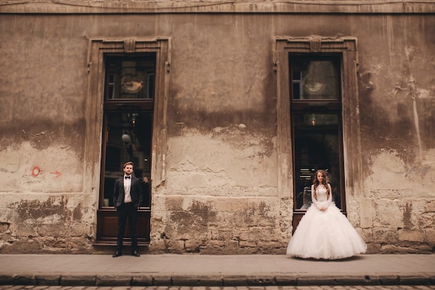 Feliz pareja de recién casados en un paseo por la antigua calle de la ciudad europea